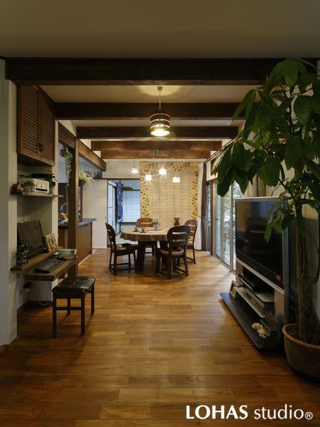 化粧梁をあしらった木の温もりを感じるダイニングです。引き戸を使い奥の和室を個室にすることも。壁を上手に使ってPCデスクを造作しました。花模様のタペストリーに心和みます。