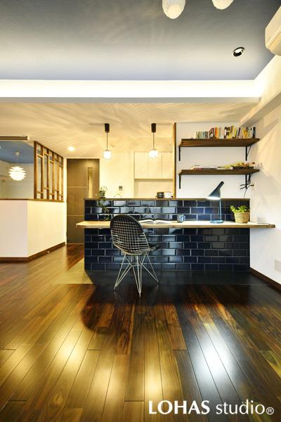 青い基調色から黒に切り替えてシックにまとめたキッチンです。床はメンテナンス性の良いフロアタイル。夜天に星が浮かぶ黒地のデザインが素敵です。カウンターには上品なテーパー形の黒タイルを施工。