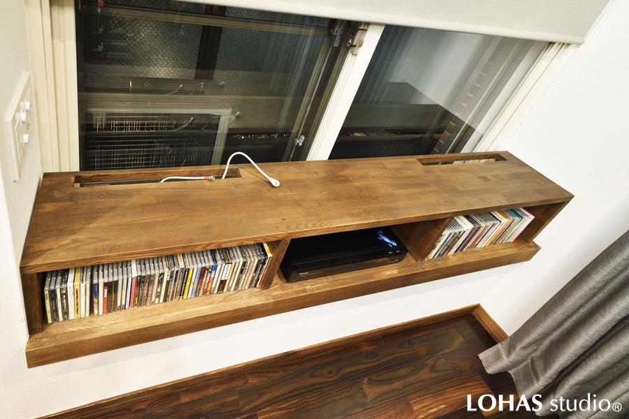 リビングの出窓に造作したTV台です。凹部ぴったりの施工で一体感のある置き家具に。ロールスクリーンを下げると窓が隠されニッチのように変化します。「造りつけ収納は新築時にしか作れない」という固定観念が覆りました。