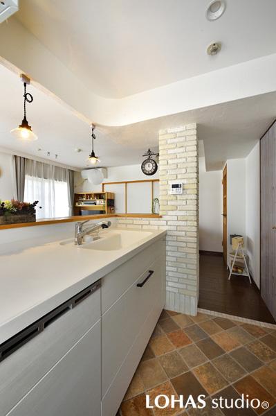 リビングを広く見渡せる白基調の明るいキッチンです。下がり壁を造作し周囲を曲線でまとめ躯体梁やパイプスペースを違和感なく隠しました。しっくいを塗装して艶のある白さに。