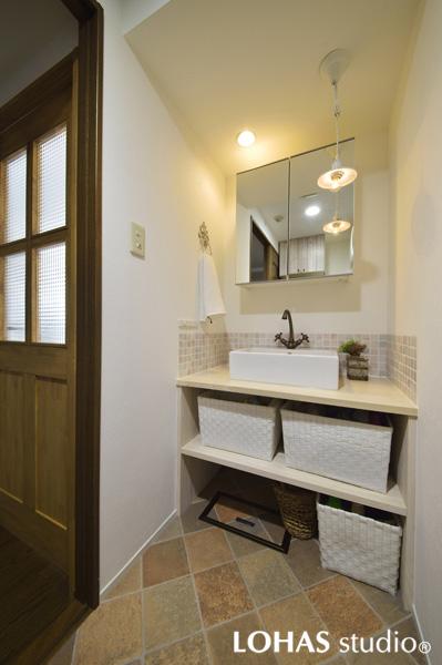 水彩タッチの淡いタイルと白い木素材で造作した大人可愛い洗面室です。ダウンライトとペンダントライトの組み合わせで空間に広がりができました。