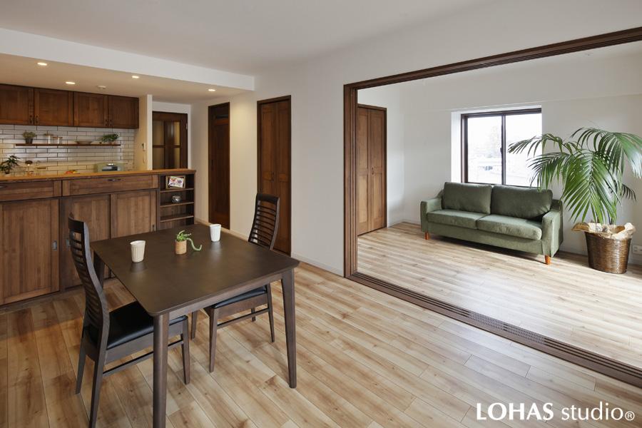 カフェのような落ち着いた雰囲気のLDKと洋室です。
無垢材を使って家具や建具を造作し温かな世界観を造りました。石目調の白い壁は優しい手触りのエコクロスです。