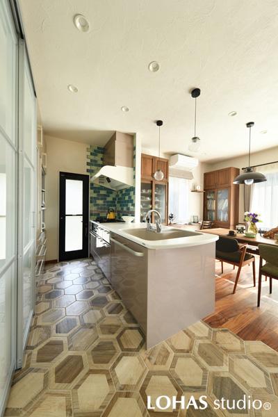六角形のタイルが印象的なオープンキッチンです。下がり壁を無くして採光を改善しました。壁のタイルの配置は奥様立ち合いのもとで決定しています。