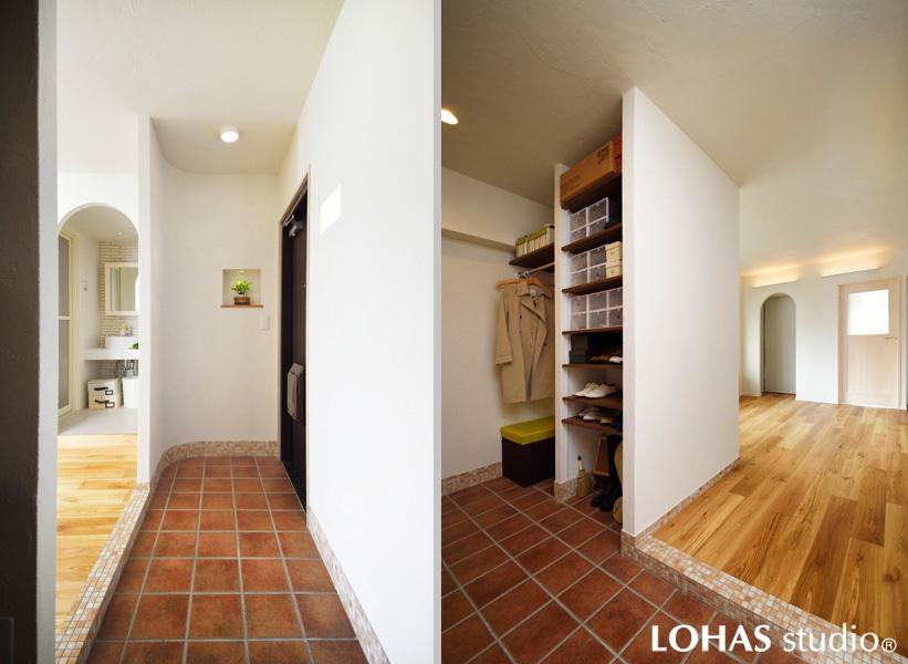 クローク収納を造作した広いタタキの玄関です。自然石の風情漂うタイルを土間に施工。玄関正面の壁を曲線で造り圧迫感を軽減しました。框は明るいモザイクタイルです。