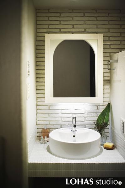 白を基調にしたアンティーク風の洗面室です。カウンターや棚は素材にこだわりオリジナルで造りました。珪藻土を施工した壁面が独特の質感を出しています。