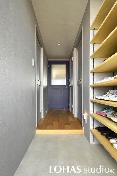 ネイビーに彩られた扉がアクセントとなった廊下・玄関です。LDKと統一感を持たせ、壁や天井をグレーに塗装。玄関収納もオープンにしました。靴の出し入れがしやすいことはもちろん、空間をスッキリさせる役割も。