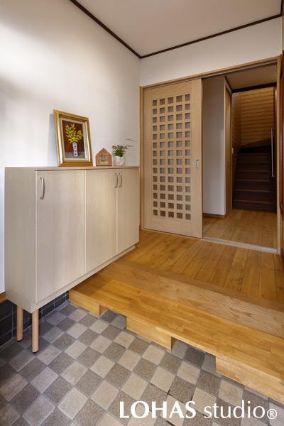 使い勝手が向上した玄関です。将来を見据えて段差を軽減するために作られた式台は、ベンチとして使うこともできとても便利。ホールとの間には、愛猫の飛び出し防止に引き戸を新設しました。