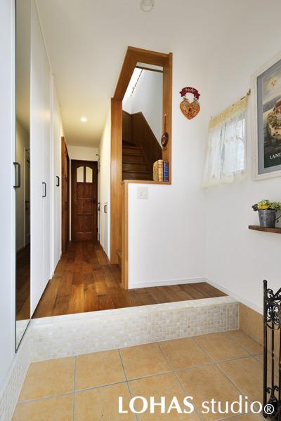 さり気ないタイルづかいがお洒落な玄関です。鏡を含めた壁一面には大容量の収納を完備して、家族全員分の靴だけでなく、コートなど上着もかけられるクロゼットも用意。いつでもスッキリと使えるようになりました。