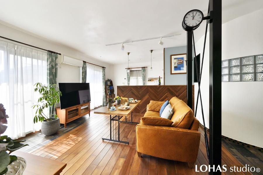 間取りの変更によって開放的になったLDKです。奥にみえる曲線の壁が、堅い印象になりがちな直線の空間をやわらげて好印象。更に床は無垢のオーク材を、壁・天井にはしっくいを用いてぬくもりをプラスしました。