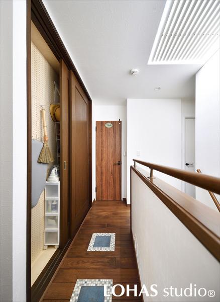 飛び石を思わせるタイルで遊びゴコロを効かせた廊下です。浴室を広げたぶん狭くなった収納スペースには、有孔ボードを設置して吊り下げる収納に。わずかな隙間も見逃さずに有効活用しました。