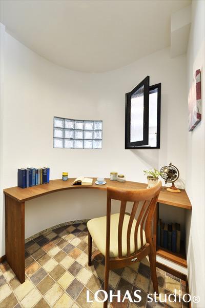 ゆるやかな曲線がポイントとなった、パントリーの奥に作られた奥様の個室です。カウンターを先に造作し、カーブに合わせてあとから壁を設けるといった、職人の手仕事が光った空間になりました。ガラスブロックと窓で風どおりもよく、ほどよく趣味に没頭できます。