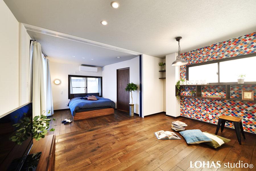 ご家族がプライベートも楽しめるように作られたセカンドリビングです。壁一面に施工されたミックスタイルが賑やかですが、その他は潔くシンプルに。ベッドスペースの扉の先はウォークインクロゼットとなっています。