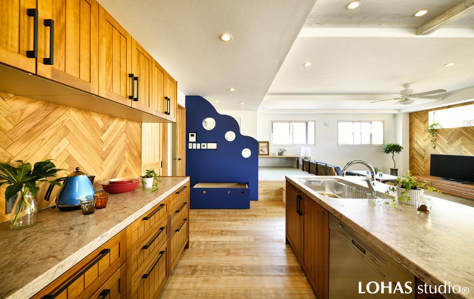 まるで波を思わせるユニークなカタチのアクセント壁には、インターホンや床暖房のスイッチをひとまとめにしてすっきりと。スキップフロアとの境を区切るだけでなく、下が引き出し収納になっていて便利です。