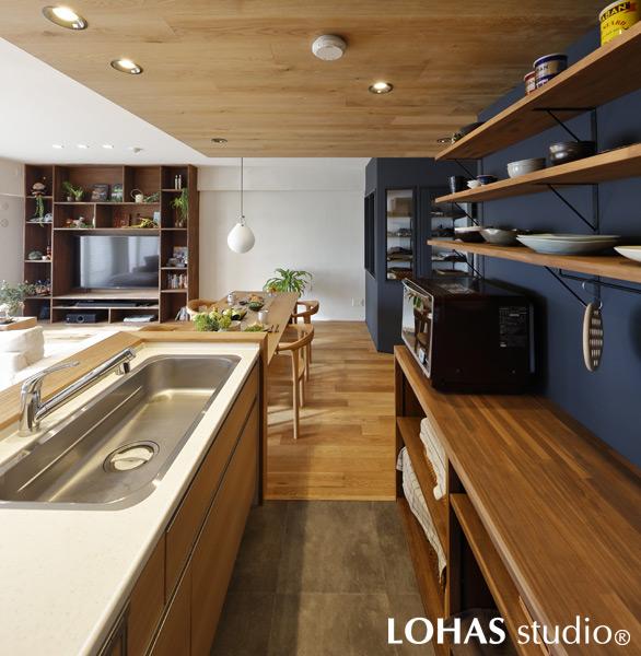 ウッディな下がり天井で雰囲気を演出したキッチンです。もちろん不燃性のウッドパネルを使用しているので安心。壁面は重めのカラーで塗装して、あえてシンプルな作りのカップボードを造作しました。