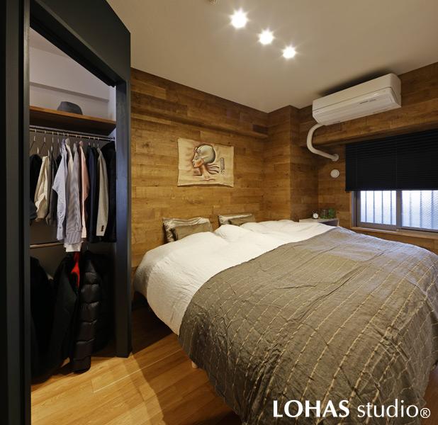 LDKに比べて重厚感の感じられるベッドルームです。経年変化の加工を施した2色のバーンオークを壁へ乱尺貼りすることで、山奥の山小屋（ヒュッテ）で過ごした感覚に浸れる空間となりました。