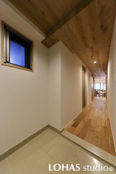 シンプルナチュラルな装いの玄関・廊下です。ドアを開けてわが家に入れば、一歩目からあたたかな木のぬくもりに包まれます。オープンにしたLDKの様子もみえ、風の通り道にもなっています。