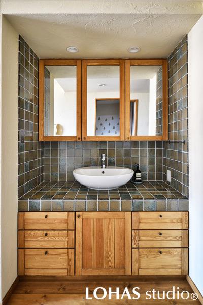 LDKと繋がった廊下にもってきた洗面台です。あえてここに移動させることによって、玄関から帰ってそのまま手洗いができるといったメリットも。釉薬の独特の風合いが美しいタイルを施工し、インテリアのアクセントとなっています。