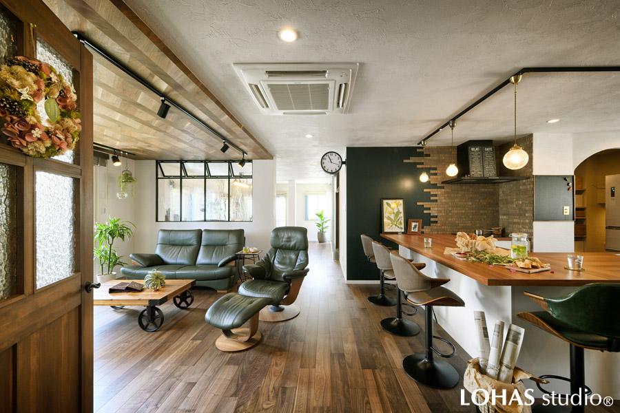 奥様こだわりの、大きなコの字型造作キッチンです。コンロ前にはスクラッチ模様が特徴のタイルを施工し、カウンターテーブルにはお洒落なペンダントライトを吊り下げてカフェスタイルに仕上げました。グリーンの壁面は黒板仕様で、プリントを留めたり、お子様のお絵かきにも使えます。