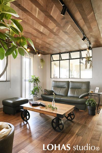 天井のワンショートヘリンボーンが目を惹くリビングです。仕切り壁には造作のアイアン窓を設置して、光が降り注ぐ明るく開放的な空間に。すべり出し窓で風通しもよく快適に過ごせます。