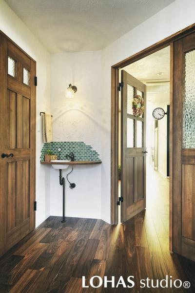 玄関にあるのがこの洗面スペースです。お子様はもちろんのこと、散歩帰りのワンちゃんの足を洗えるように、カウンターを少し長めに作っています。リフォームの記念に、壁にはご家族の手形が。家に帰ってくるたび笑顔がこぼれます。