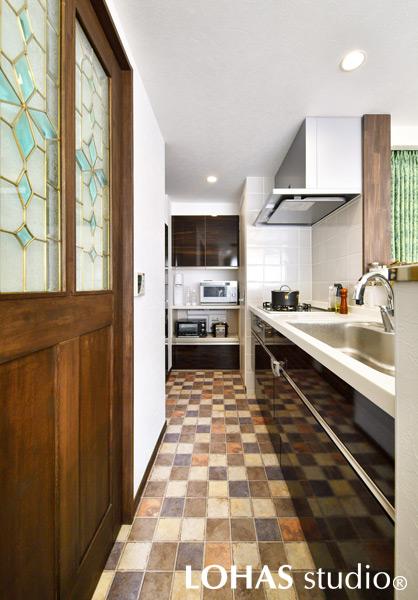 設備を取り換えて使い勝手が向上したキッチンです。レトロな色合いのクッションフロアで可愛らしく。突き当たりにはカップボードとパントリーも備え、最低限の動きで調理が行えて便利です。