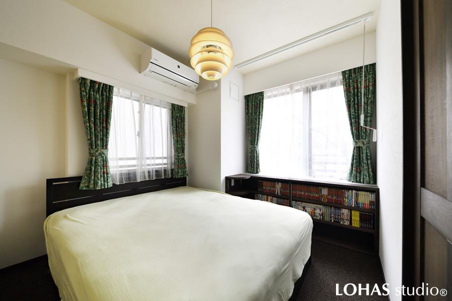 壁に本棚を造りつけた寝室です。収納量は3段分とたっぷりとご用意しました。天井には格納式の室内用物干しを設置。湿気の対策に天井へ珪藻土を施工しています。