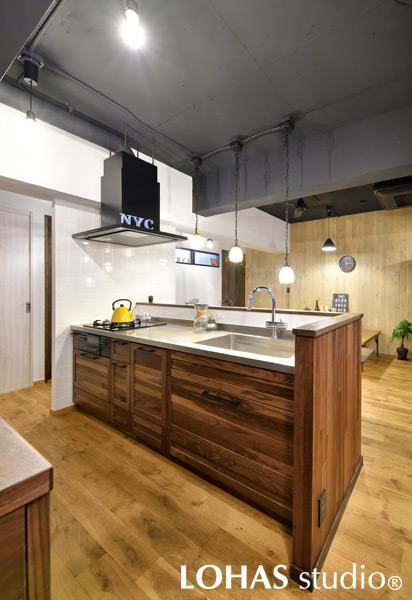 無垢材を採用して空間と統一感を持たせたキッチンです。レンジフードのダクトも現しでインテリアの一部に。回遊性があるので使い勝手も抜群です。