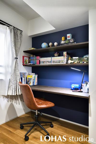 ご長男の個室には、柱の出っ張りをうまく活かしてカウンターデスクを造作しました。壁をブルーに塗装して棚板を取り付けたシンプルなデスクなので、年齢を重ねても長く使えるようになっています。
