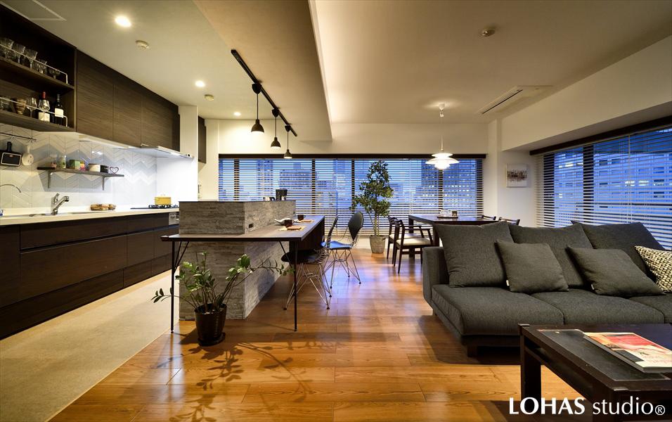 開口部からの夜景が美しく映えるLDKです。思い切ってメインの照明を全て間接照明で補い、天井へと伸びた光がよりムーディーな雰囲気を演出。上質なホテルを思わせる空間となりました。