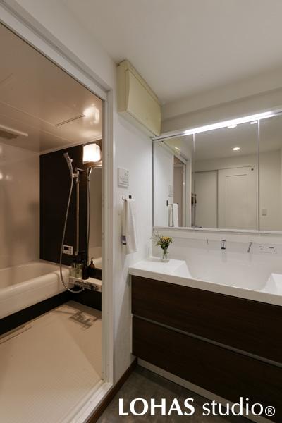 LDKに合わせて大人っぽくまとめた洗面＆浴室です。既存のものから一新させました。大きな三面鏡はトップライト付きで使い勝手バツグン。浴槽もゆとりを持った広さを確保しています。