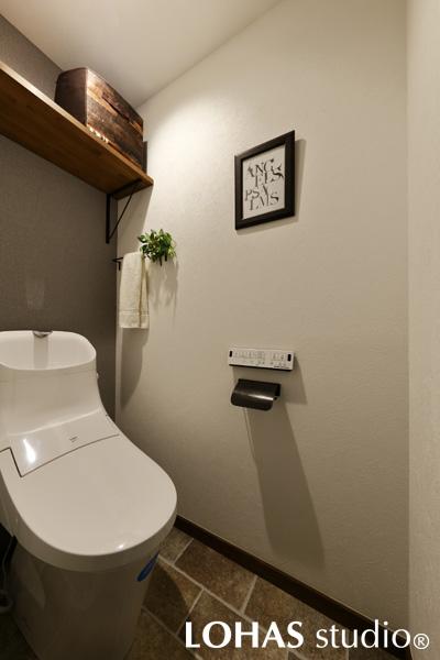 設備を取り換えて利便性を向上させたトイレです。壁の一面だけクロスの色を変え、床は石畳を思わせるパターンをセレクト。お施主様がご用意されたアイアンのアクセサリーが、アクセントになっています。