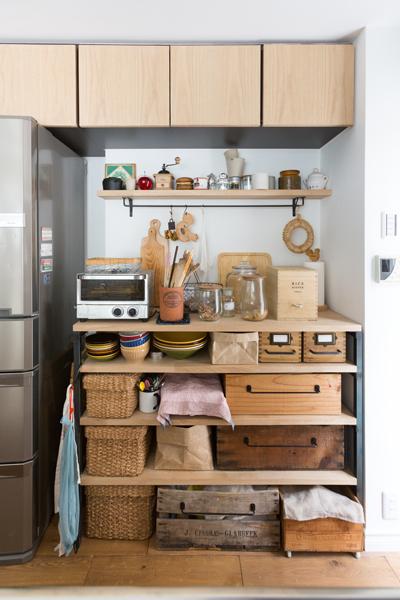 キッチンに造作したオープン収納です。お気に入りの食器やキッチンツールを並べるだけで可愛いディスプレイになりました。取り付けたウォールバーは「ぶらさげる」収納に便利。吊り戸棚は扉だけ新しく交換してコストを低減しています。