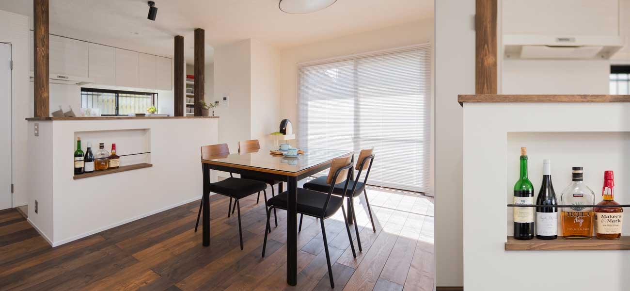 窓に面する明るいダイニングです。カウンターには瓶などを収納できるニッチを造作。床はモザイク風に配色した色違いのフローリング。