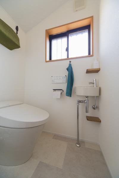 斜天井をもつ清潔感あるトイレです。タンクレストイレを採用して室内は広々。コーナーに小さな棚を造作しました。