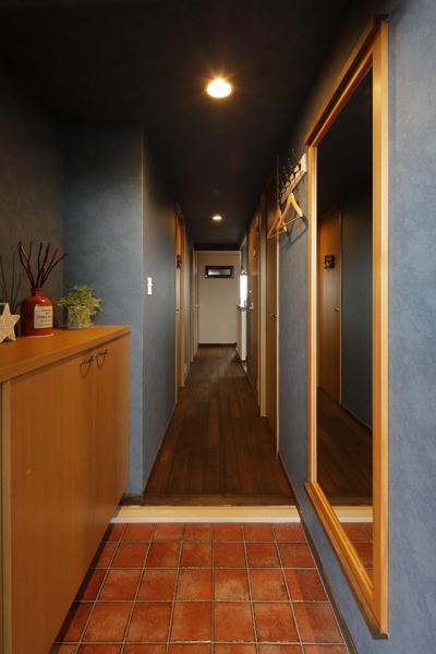 ヴィンテージな装いの玄関です。斑のある擦れた風貌の壁面は防カビ性のあるクロスです。既存のフローリングやタイル・框と よく馴染み 新しい風景を創り上げています。