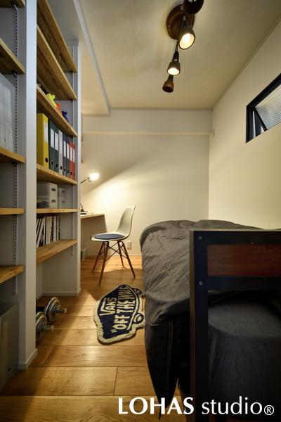 程よいおこもり感のある書斎です。必要最低限のモノだけ置かれたスペースの奥にデスクを備えて、作業に集中して取り組めます。閉塞的になりがちな空間ですが、玄関側の壁に室内窓を取り付けて採光の工夫をしています。