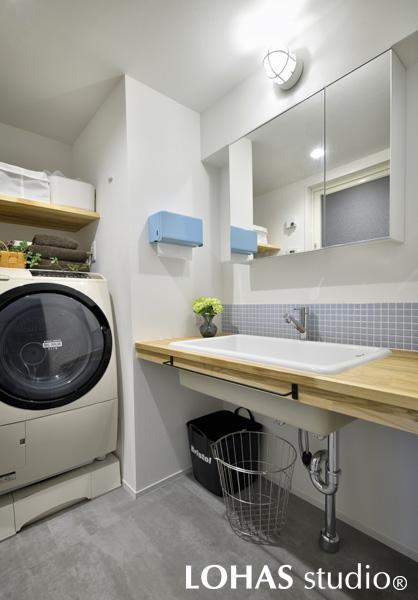 機能的でシンプルなパウダールームです。大きなホワイトの洗面ボウルは、なんと病院用。汚れた洋服も洗いやすい広さを持っているので、好んで選ぶお客様も多くいらっしゃいます。床には、キッチンと揃えてモルタル調のフロアタイルを貼りました。