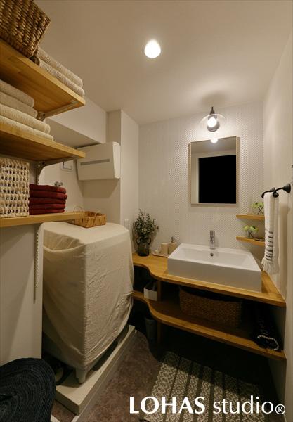 ナチュラルにまとめられた洗面室の中でも一際目を惹くのが、洗面まわりのタイル使い。長方形のタイルはカジュアルな印象があるため、細かなヘリンボーン貼りのタイルをセレクトし、落ち着きのある大人な洗面空間となりました。可動式・固定式の棚をそれぞれ用意して、使い勝手も抜群です。