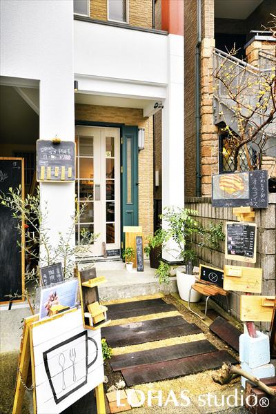 手書きの看板やPOPで、ハンドメイドの温もりに溢れたアプローチ周りです。道行く人々に対してお店だと分かってもらえるよう、アイテム選びで「店舗感」を演出。興味を持ったお客さまが不安にならないよう、中の様子をみることのできるガラス製の扉を選んでいます。
