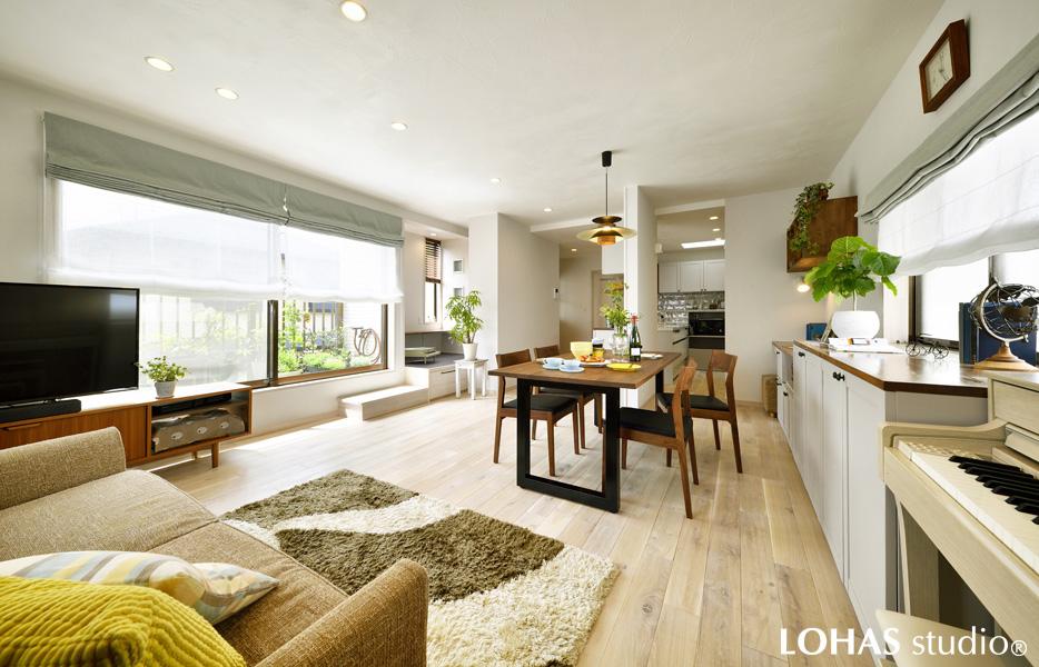 エコクロスと漆喰のホワイトが爽やかな、瑞々しいグリーンの一層映えるLDKです。床材には無垢オークをロハスオイルのホワイトで塗装して、より柔らかな印象となりました。テーブルや小物のブラックがアクセントとなり空間を上質にまとめています。