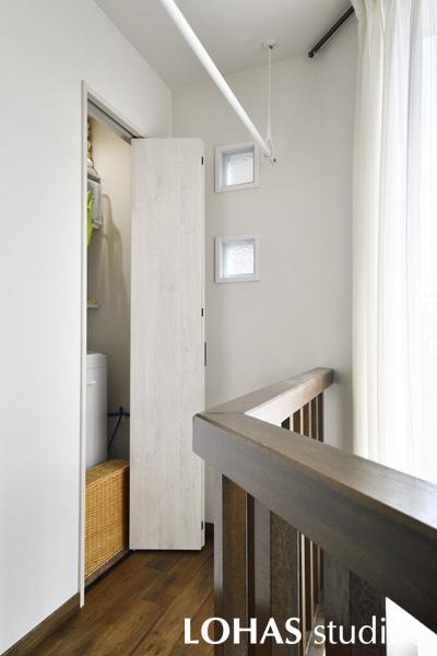 廊下に面した場所には洗濯機のスペースが。折り戸を取り付けているので、普段は視界に入ることがなくスマートです。すぐそばの天井には室内用の物干しを設置して、移動することなく洗濯物を干すことが出来るようになっています。