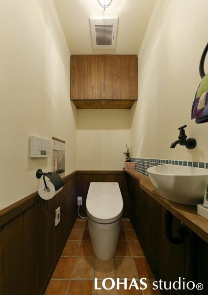 ナチュラルな木目を中心にまとめられたトイレです。手洗いボウルの水ハネ防止に貼られたタイルが色鮮やか。壁にマグネットが使える下地材を入れているため、傷を付けることなくデコレーションが楽しめます。
