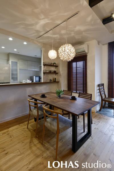 拡散されたライトの光が印象的なダイニングです。Hさまがご用意された花のようなライトは、カピス貝を利用して作られたもの。ダイニングに華やかさを添えています。キッチンとの間には飾り棚を設けました。背面にタイルでアクセントを付けた可愛らしいコーナーとなっています。