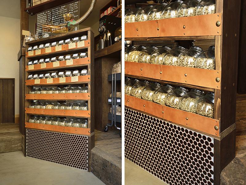 ショップに入ってすぐに目に留まるのが、このオーダーメイドの商品棚。Iさまが厳選した珈琲豆を入れた瓶を整然と陳列するため、mm単位でサイズを調節している。また、使い込まれたようなパインの集成材や革などを採用し、下部には丸い小さなタイルを貼り合わせノスタルジーを演出。