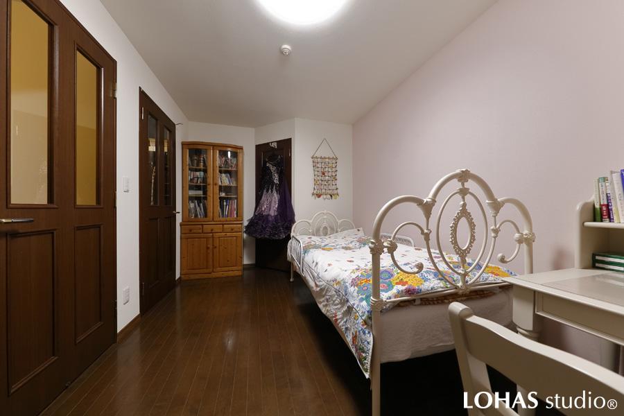 フェミニンな印象の奥さまの寝室です。床は既存のままですが、壁と天井のクロスを張り替えました。ポイントとして一面だけ、繊細なピンク色をチョイス。甘くなり過ぎず、お手持ちのホワイトの家具と調和してエレガントな雰囲気になりました。