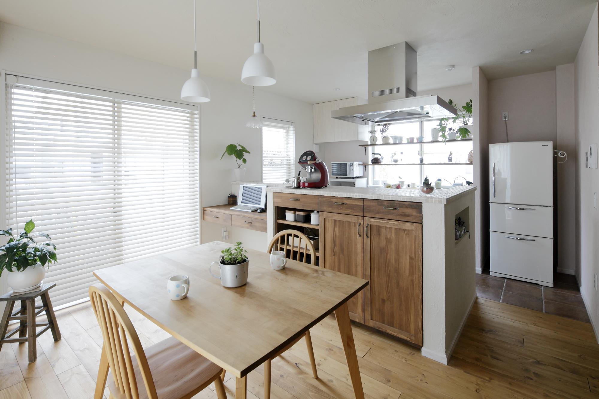 ナチュラルテイストの木目と清潔感たっぷりのタイルで飾ったキッチンカウンターがさわやかな印象のリビングダイニング。ホワイトが基調となった部屋には木漏れ日が美しく輝きます。