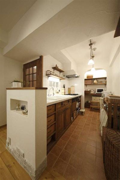 カウンターや壁面に採用した白いタイル。廊下への採光も配慮して、壁には壁のガラスブロックを。リビングと繋がる開放的なキッチンを実現しました。