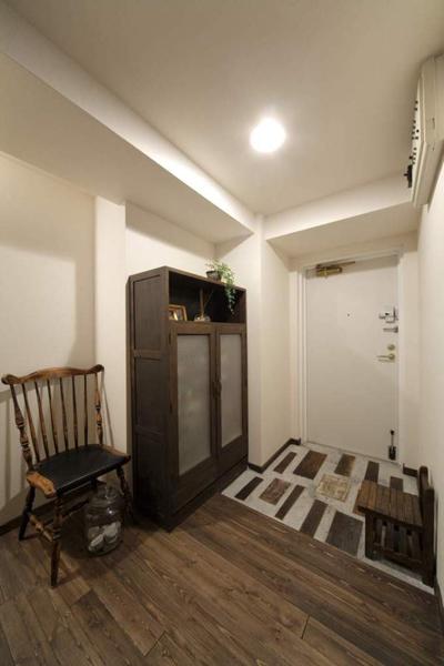 玄関入り口の床は、奥様が古材を購入し自ら施工。センス良く並べられた古材と靴箱・イスの調和がみごとです。