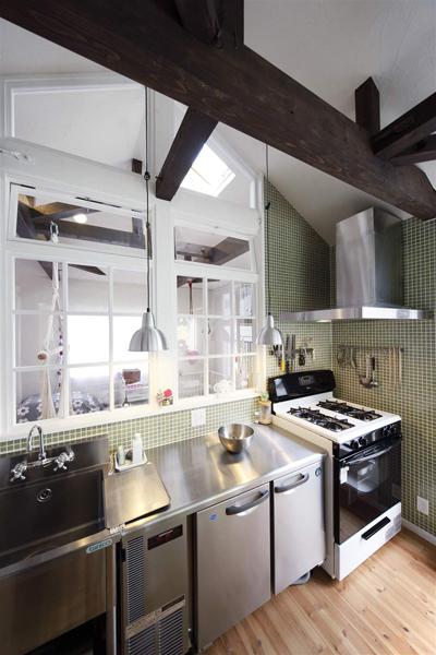 キッチン壁部分は濃いグリーンのタイルで変化を付け、業務用キッチンでカフェのような印象に。