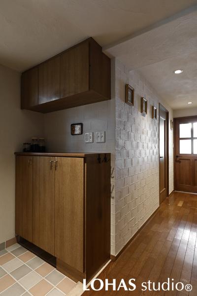 ミックス貼りのタイルが軽やかな印象の玄関周りです。玄関からLDKに続く廊下へと、壁に珪藻土でレンガ調のパターンを施しました。飾られた絵画も相まって、まるでギャラリーのような印象です。